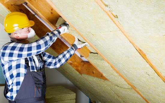 Roofing contractor inspecting rafters of house during roofing inspection by Rochester Roofing company of Rochester Minnesota