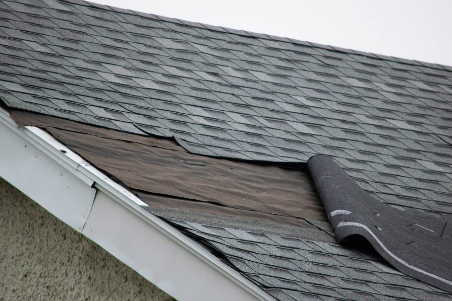 Damaged shingles on house inspected by Rochester Roofing company of Rochester Minnesota