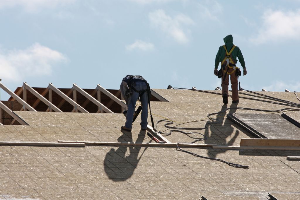 Roofers working on the roof of residential house